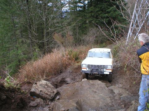 1978 Ford Bronco - A white 1978 Ford Bronco navigates a challenging muddy and rocky off-road course.