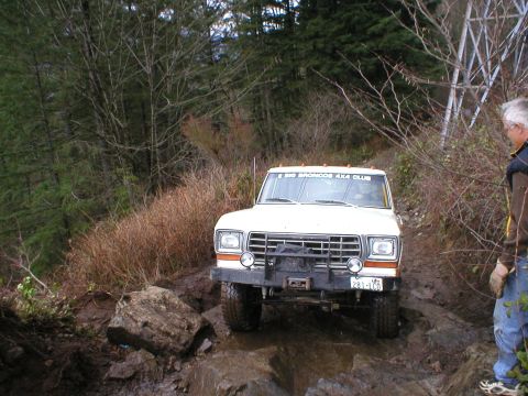 1978 Ford Bronco - 1978 Ford Bronco navigating a challenging muddy and rocky off-road trail.