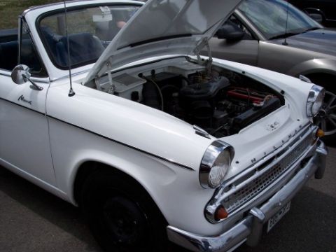 1972 Ford Ranchero - A white convertible's hood is open, revealing the engine compartment. A second vehicle is visible behind it.