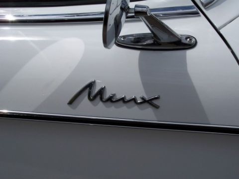 1972 Ford Ranchero - Close-up of the 'Minx' badge on a white vehicle, with a chrome side mirror visible.