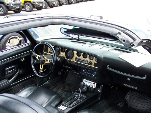 Interior of a 1977 Pontiac Firebird Trans Am with aftermarket steering wheel and radio
