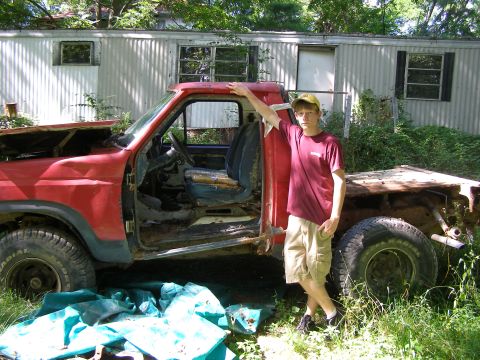 1984 Ford Bronco - This heavily modified red pickup truck appears to be a project vehicle, not a 1984 Ford Bronco.