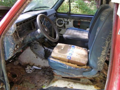 1984 Ford Bronco - The interior of a 1984 Ford Bronco shows significant wear and tear on the seats and floor.
