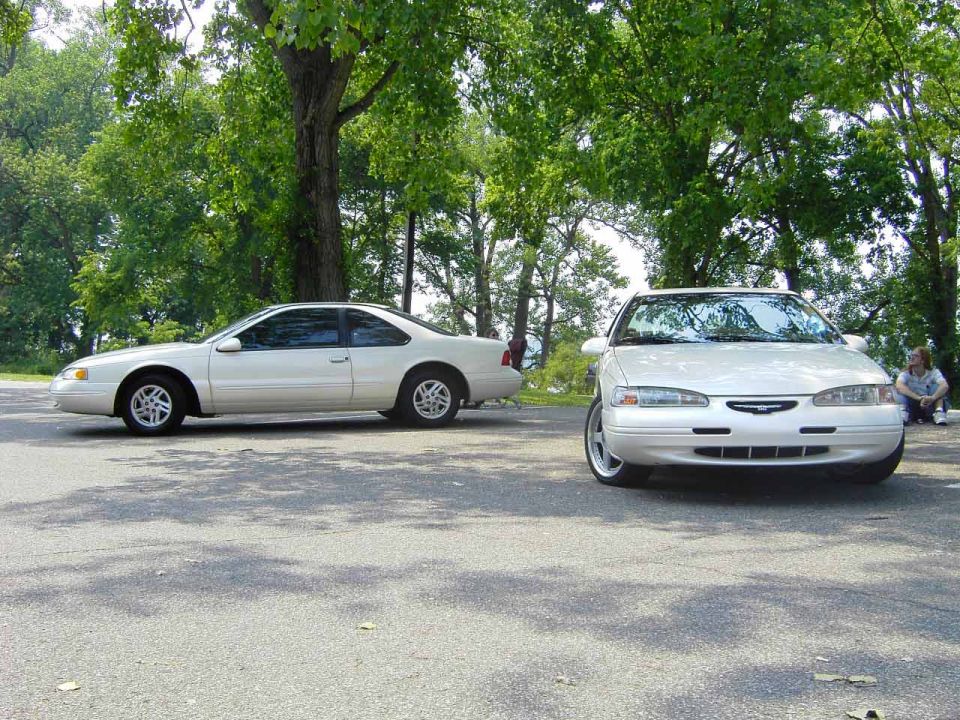 Two white 1996 Ford Thunderbirds parked front-to-front