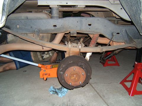 1988 Ford Bronco - The rear suspension and axle assembly of a vehicle is shown while undergoing maintenance.