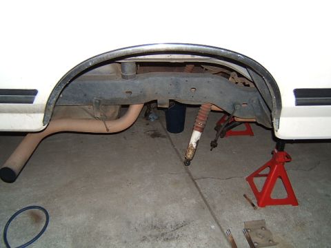 1988 Ford Bronco - Rear suspension components of a white vehicle are visible, with the axle supported by jack stands.