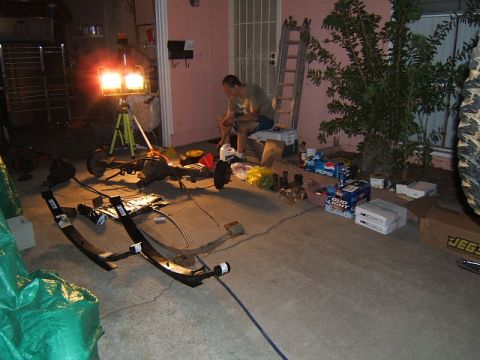 1988 Ford Bronco - Parts for vehicle repair laid out in a driveway, including an axle and leaf springs.