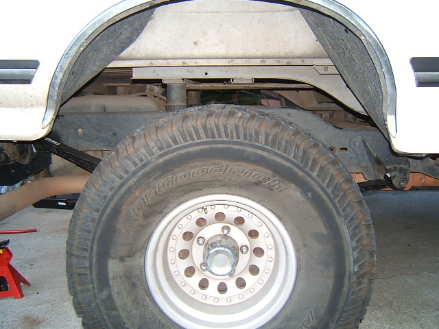 Close-up of a vehicle's rear tire and leaf spring suspension system