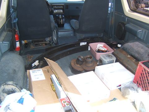 1988 Ford Bronco - Interior view of a 1988 Ford Bronco packed with various automotive parts, suggesting recent maintenance or upgrades.