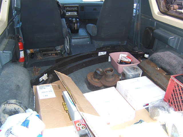 1988 Ford Bronco interior with parts, including leaf springs and hubs