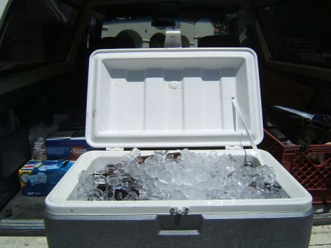 1988 Ford Bronco - Cooler full of ice and bottles in the back of a vehicle with cases of beer.