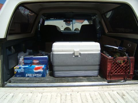 1988 Ford Bronco - View inside the bed of a pickup truck, loaded with a cooler, Pepsi, and a red crate.