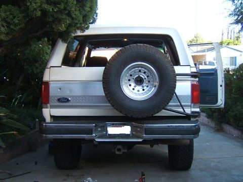 1988 Ford Bronco - Rear view of a white 1988 Ford Bronco, a spare tire mounted externally on the tailgate.
