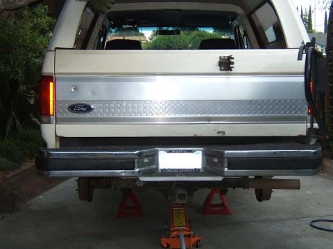 1988 Ford Bronco - Rear view of a 1988 Ford Bronco being worked on, lifted on jack stands.