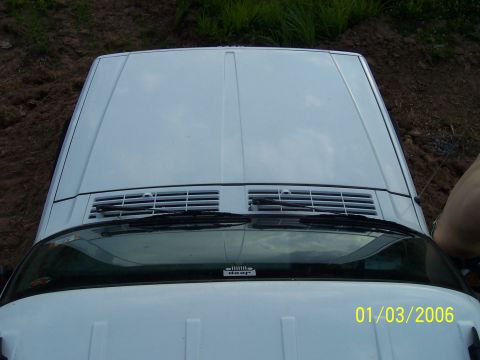 1995 Jeep Cherokee - Top-down view of a 1995 Jeep Cherokee's hood and windshield, showing the Jeep logo.