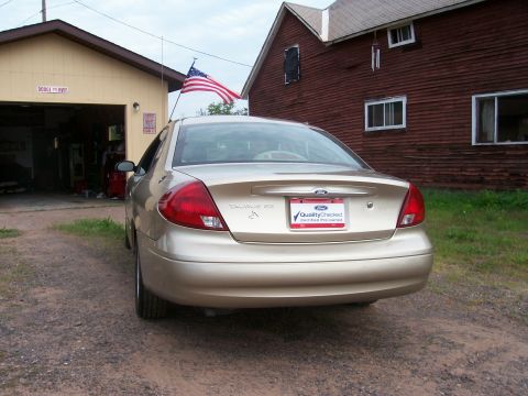 2000 Ford Taurus - Rear view of a gold 2000 Ford Taurus, identified by its 'Taurus SE' badging and the 'Quality Checked' license plate frame.