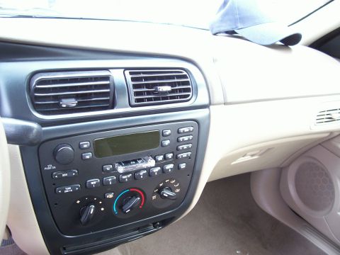 2000 Ford Taurus - Dashboard of a 2000 Ford Taurus, the center console with radio and climate controls, and air vents above.