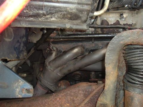 1991 Ford Bronco - The exhaust manifold and surrounding engine parts show significant rust and wear.