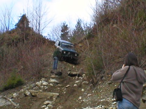 1978 Ford Bronco - A 1978 Ford Bronco navigates a challenging off-road terrain with onlookers.