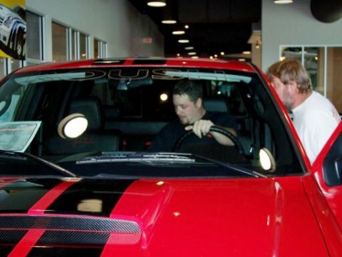 1972 Ford Ranchero - Two men are inside a red pickup truck, one behind the wheel and the other looking in through the open door.