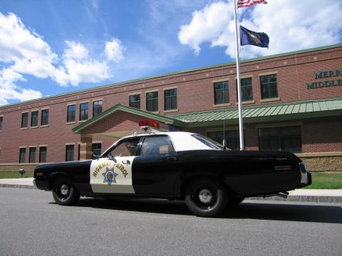 1991 Ford LTD Crown Victoria - black-and-white HIGHWAY PATROL Dodge sedan parked along the curb in front of the brick Merrimack Middle School building.