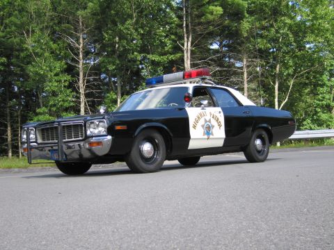 1991 Ford LTD Crown Victoria - black-and-white California Highway Patrol cruiser with grille guard and lightbar, shown front quarter on a roadway.