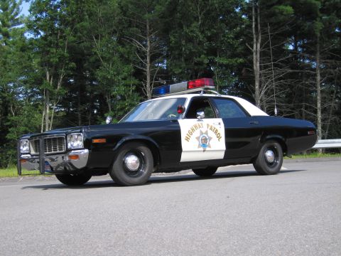 1991 Ford LTD Crown Victoria - black-and-white California Highway Patrol cruiser with push bar and roof lights, front three-quarter view on pavement.