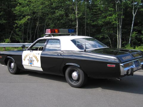 1991 Ford LTD Crown Victoria - black-and-white California Highway Patrol cruiser viewed from the rear three-quarter, door emblem and lightbar visible.