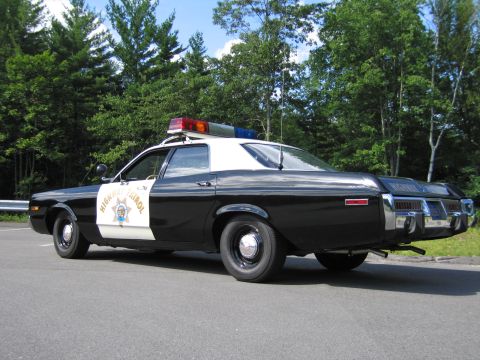 1991 Ford LTD Crown Victoria - black-and-white Highway Patrol sedan shown from the rear quarter with roof lightbar and antenna, parked on pavement.