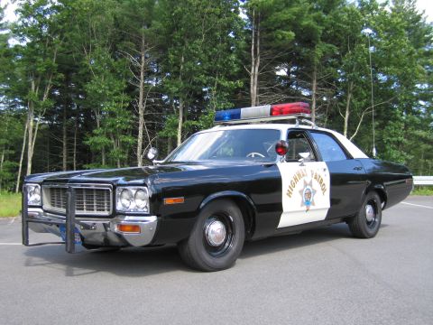 1991 Ford LTD Crown Victoria - black-and-white California Highway Patrol cruiser with push bar and lightbar, front three-quarter view on pavement.