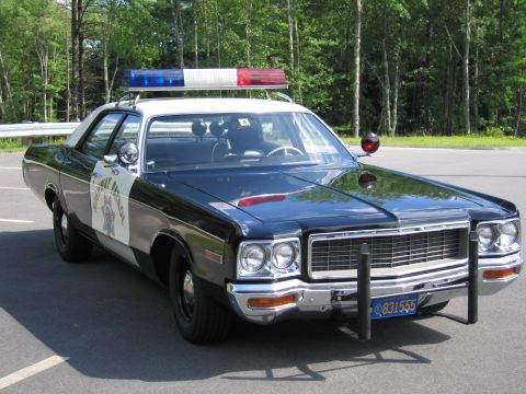 1991 Ford LTD Crown Victoria - black-and-white Highway Patrol cruiser, front three-quarter view with grille guard, lightbar and California plate 831555.
