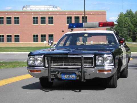1991 Ford LTD Crown Victoria - Head-on front view of a dark Highway Patrol police sedan with chrome grille, grille guard and California plate 831555.