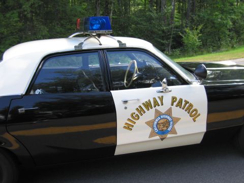 1991 Ford LTD Crown Victoria - Close-up of a black-and-white police car door showing HIGHWAY PATROL lettering and the California Highway Patrol star emblem.