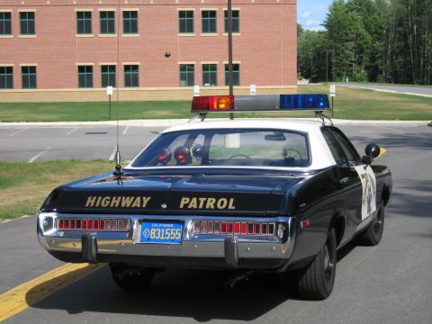 1991 Ford LTD Crown Victoria - Rear view of a dark Highway Patrol police sedan with HIGHWAY PATROL lettering, full-width tail lights and California plate 831555.