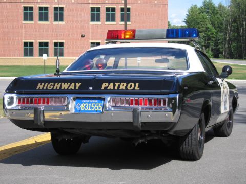 1991 Ford LTD Crown Victoria - Rear view of a Highway Patrol police sedan showing roof lightbar, HIGHWAY PATROL lettering and California plate 831555.