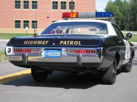 1991 Ford LTD Crown Victoria - Rear quarter view of a black-and-white Highway Patrol police sedan with chrome bumper and California plate 831555.