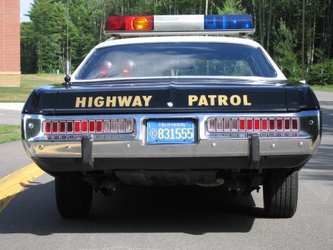 1991 Ford LTD Crown Victoria - Head-on rear view of a black-and-white Highway Patrol police sedan with full-width tail lights and California plate 831555.