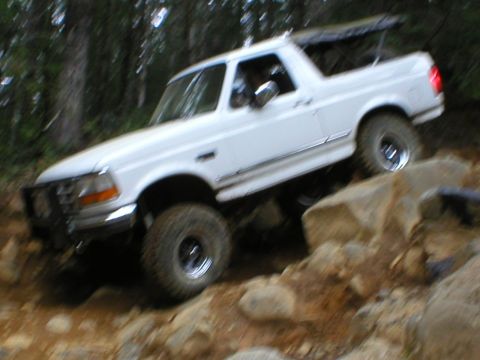 1978 Ford Bronco - White Ford Bronco navigating rocky terrain off-road.