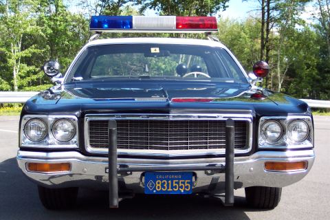 1991 Ford LTD Crown Victoria - Head-on front view of a black police sedan with a red and blue roof lightbar, chrome push bumper, and California license plate 831555.