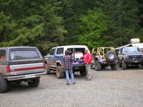 1978 Ford Bronco - Several off-road vehicles are gathered in a wooded area.