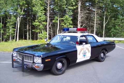 1991 Ford LTD Crown Victoria - Front three-quarter view of a black-and-white CHP sedan with Highway Patrol door emblem, roof emergency lights, and push bumper parked by t…
