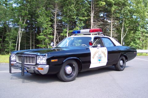 1991 Ford LTD Crown Victoria - Side-front view of a black-and-white California Highway Patrol sedan showing the door star emblem, roof lightbar, and chrome push bumper.