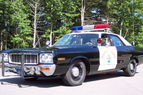 1991 Ford LTD Crown Victoria - Front three-quarter view of a black-and-white California Highway Patrol sedan with chrome push bumper, door star, and roof lightbar.