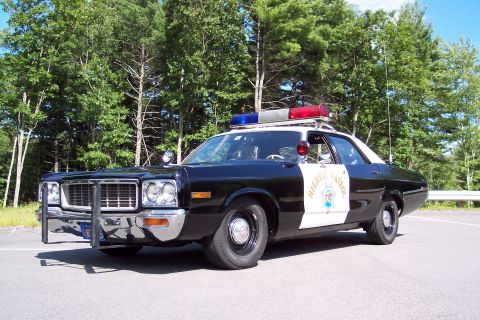 1991 Ford LTD Crown Victoria - Front-side view of a black-and-white California Highway Patrol sedan with chrome push bumper, door star emblem, and roof emergency lights.