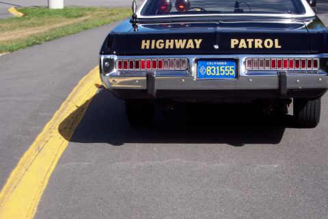 1991 Ford LTD Crown Victoria - Close rear view of a black patrol sedan's trunk with gold HIGHWAY PATROL lettering and a California license plate reading 831555.