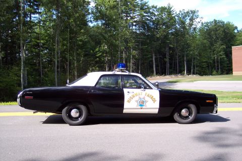1991 Ford LTD Crown Victoria - Full side profile of a black-and-white California Highway Patrol sedan with white roof, door star, and roof lightbar on a road.