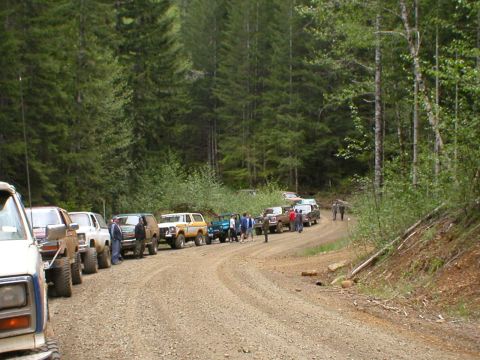 1978 Ford Bronco - A group of Ford Broncos and other SUVs parked on a dirt road during an event.