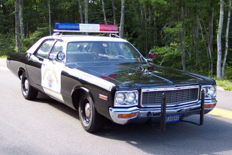 1991 Ford LTD Crown Victoria - Front three-quarter view of a black-and-white Dodge California Highway Patrol sedan with DODGE grille lettering, door star, and push bumper.