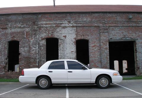 2001 Ford Crown Victoria - Side view of a white 2001 Ford Crown Victoria parked in a lot.