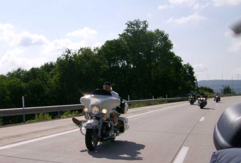 2005 BMW R1200CA ABS - A rider on a white touring motorcycle cruises down a highway, with other motorcycles visible in the distance.